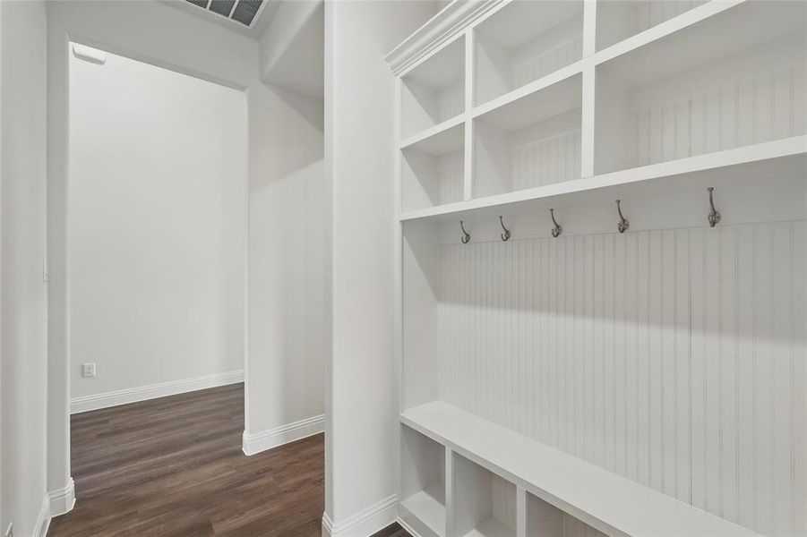 Mudroom with dark wood-style flooring, baseboards, and visible vents