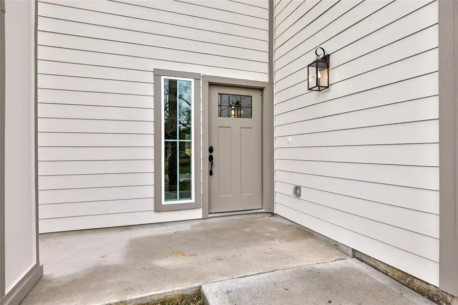 Welcoming front porch with soaring high ceiling.