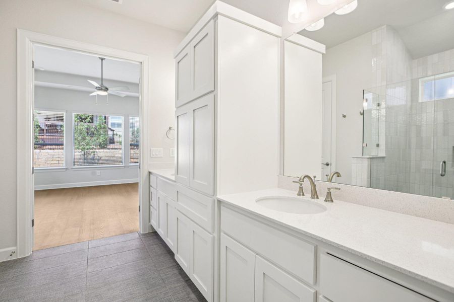 Full bathroom featuring a stall shower, vanity, and ceiling fan
