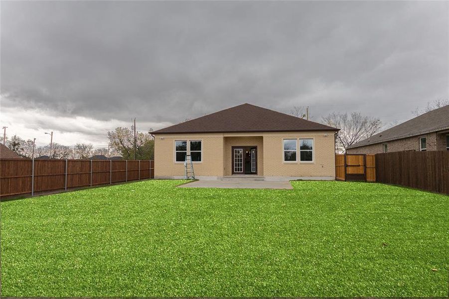 Rear view of house with a patio, brick siding, and a fenced backyard Rear view of house with a patio, brick siding, and a fenced backyard