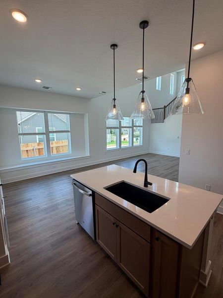 An inviting open-concept layout features a spacious kitchen island and abundant natural illumination from large windows. An inviting open-concept layout features a spacious kitchen island and abundant natural illumination from large windows.