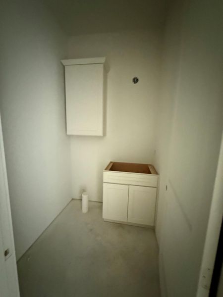 Ready for customization, this compact space features essential vanity and wall cabinets.