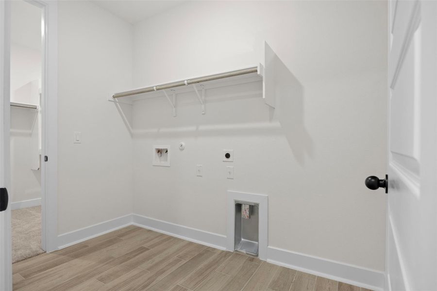 Laundry room with hookup for an electric dryer, hookup for a gas dryer, light wood-type flooring, and washer hookup Laundry room with hookup for an electric dryer, hookup for a gas dryer, light wood-type flooring, and washer hookup