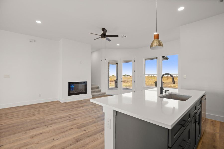 A well-lit open-concept living area boasts a modern fireplace and a kitchen island with seating. A well-lit open-concept living area boasts a modern fireplace and a kitchen island with seating.