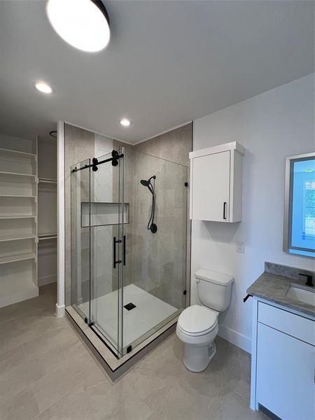 Bathroom with vanity, a shower stall, a spacious closet, and recessed lighting