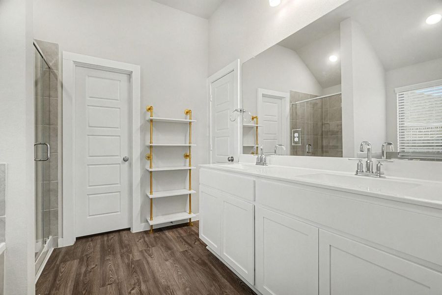 Primary bathroom presents dual sinks, a glass-standing shower, a soaking tub, and a walk-in closet. Primary bathroom presents dual sinks, a glass-standing shower, a soaking tub, and a walk-in closet.