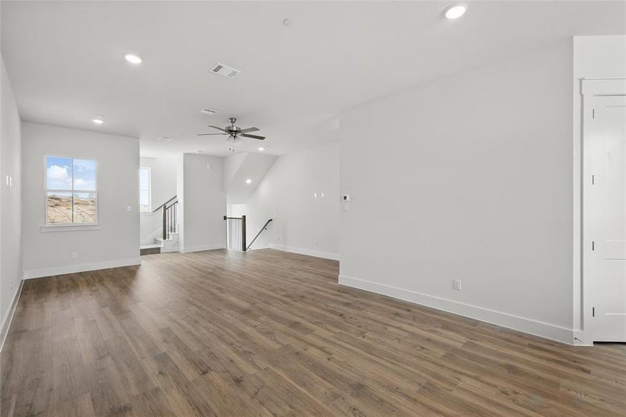 Unfurnished living room with recessed lighting, a ceiling fan, and dark wood finished floors