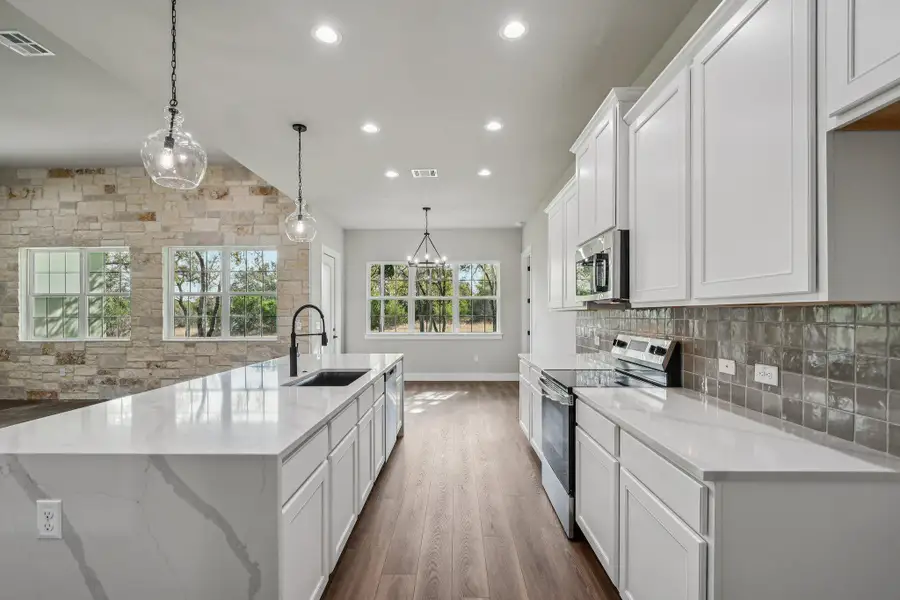 Kitchen with hanging light fixtures, stainless steel appliances, white cabinets, recessed lighting, and dark wood-style flooring