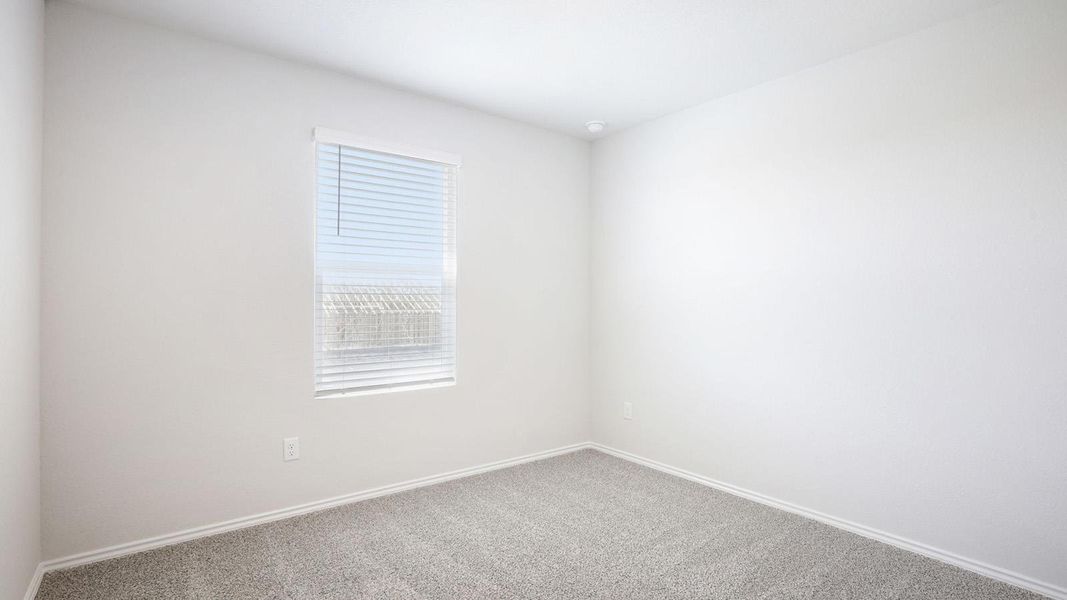 Light-filled interior space featuring neutral wall tones, gray carpet, white baseboards, a window with horizontal blinds, and a ceiling-mounted light fixture