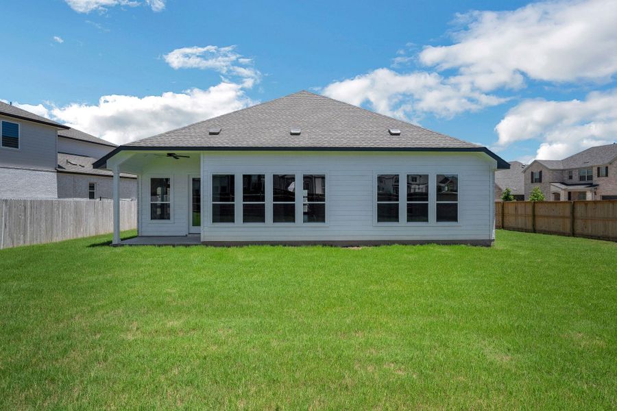 Back of house featuring roof with shingles, a fenced backyard, and a ceiling fan
