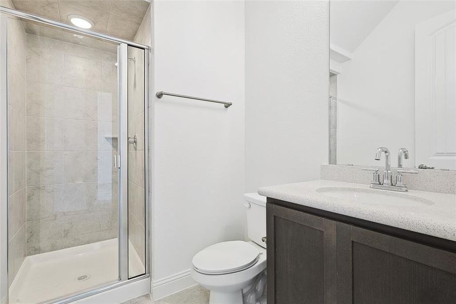 Bathroom featuring toilet, vanity, and walk in shower