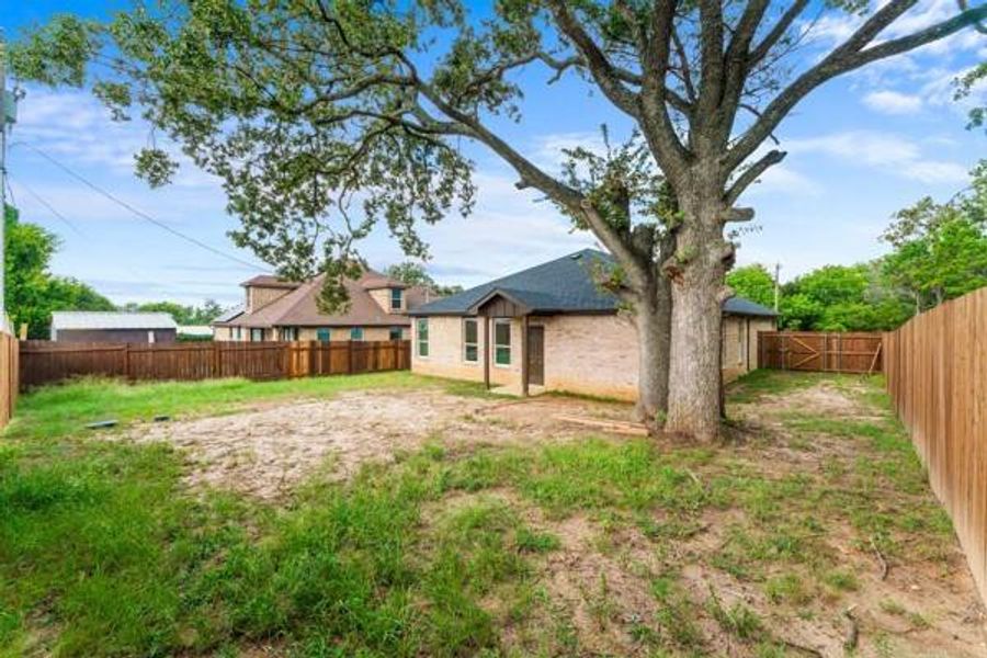 Back of property featuring a fenced backyard and brick siding Back of property featuring a fenced backyard and brick siding