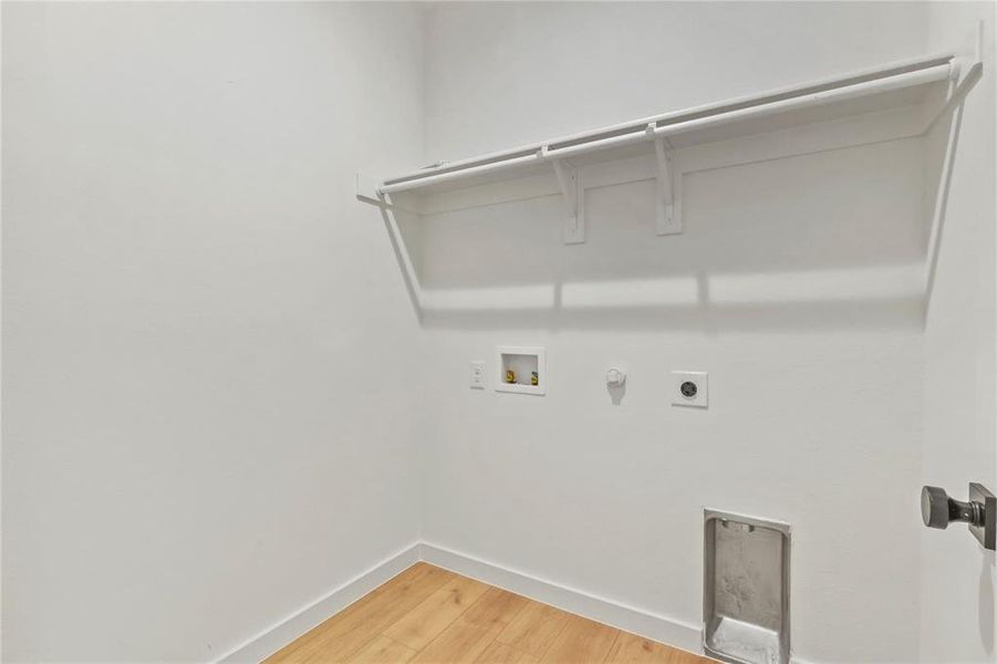 Laundry room featuring gas dryer hookup, light wood-style flooring, electric dryer hookup, and hookup for a washing machine Laundry room featuring gas dryer hookup, light wood-style flooring, electric dryer hookup, and hookup for a washing machine
