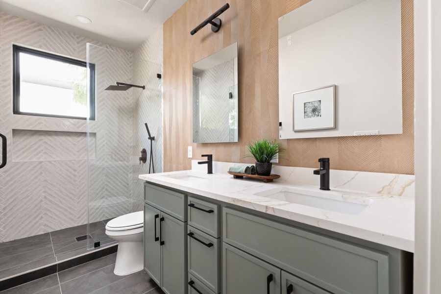 Dual vanities with sleek black fixtures enhance this well-appointed bathroom.