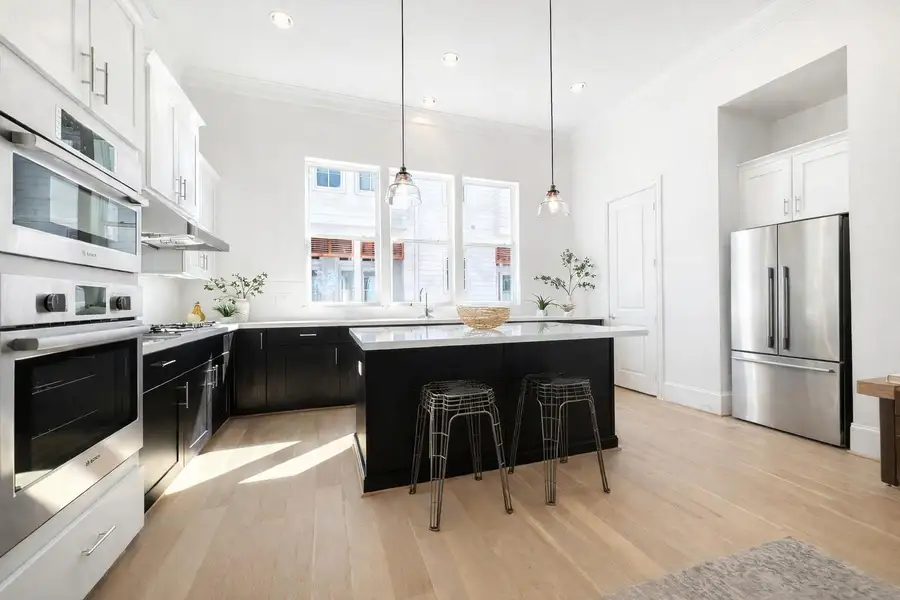 Bright and cheery kitchen with large island and elegant Bosch appliances, including refrigerator.