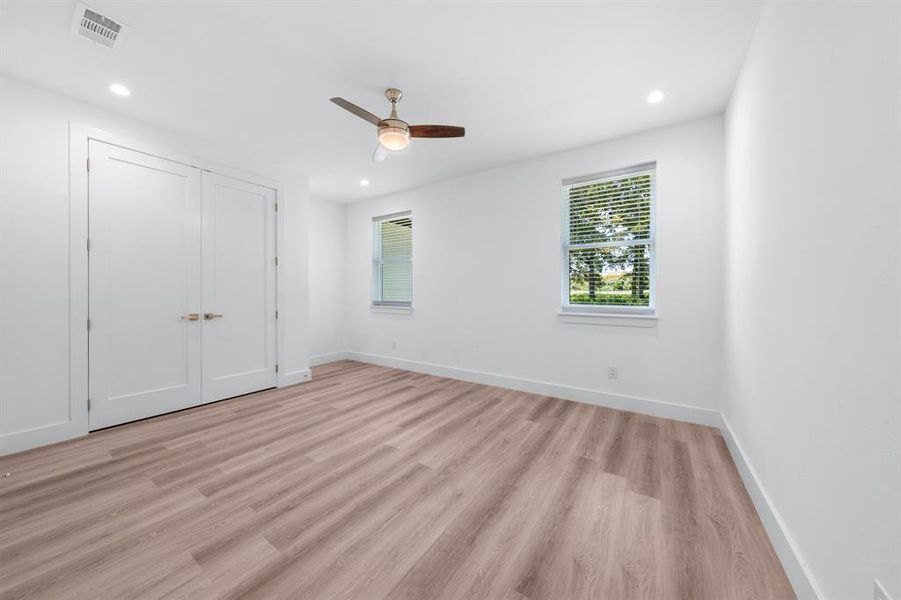 Unfurnished bedroom featuring light wood-style flooring, ceiling fan, recessed lighting, and a closet Unfurnished bedroom featuring light wood-style flooring, ceiling fan, recessed lighting, and a closet