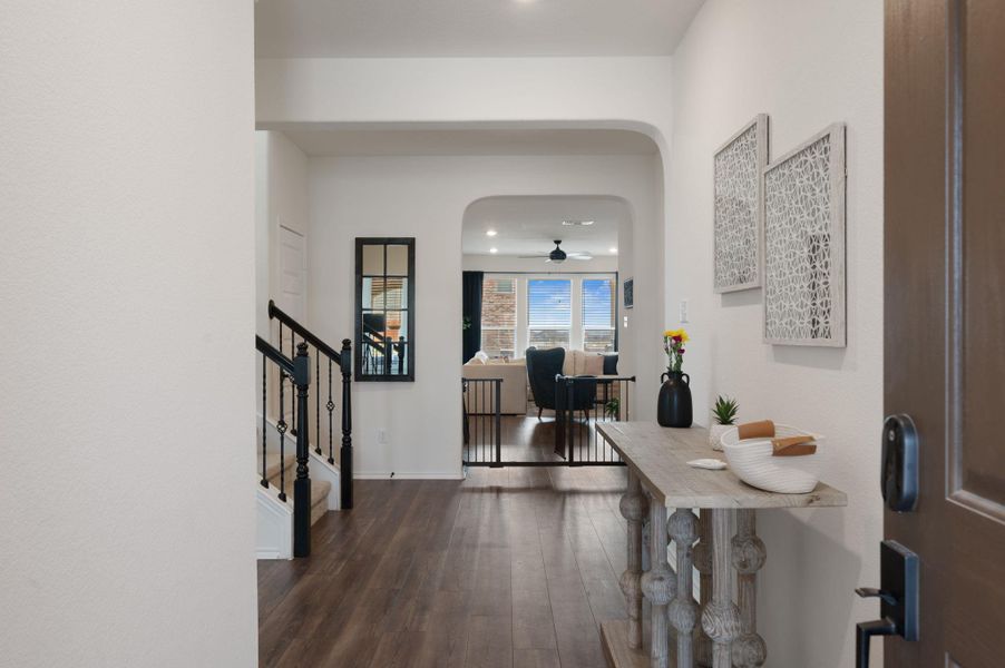 Corridor with arched walkways, dark wood finished floors, and recessed lighting