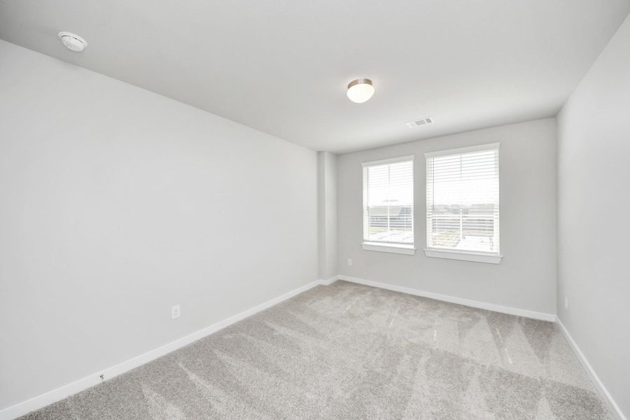 Generously sized secondary bedrooms featuring spacious closets, soft and inviting carpeting underfoot, large windows allowing plenty of natural light. Sample photo of completed home with similar plan. Actual colors and selections may vary. Call for more info.