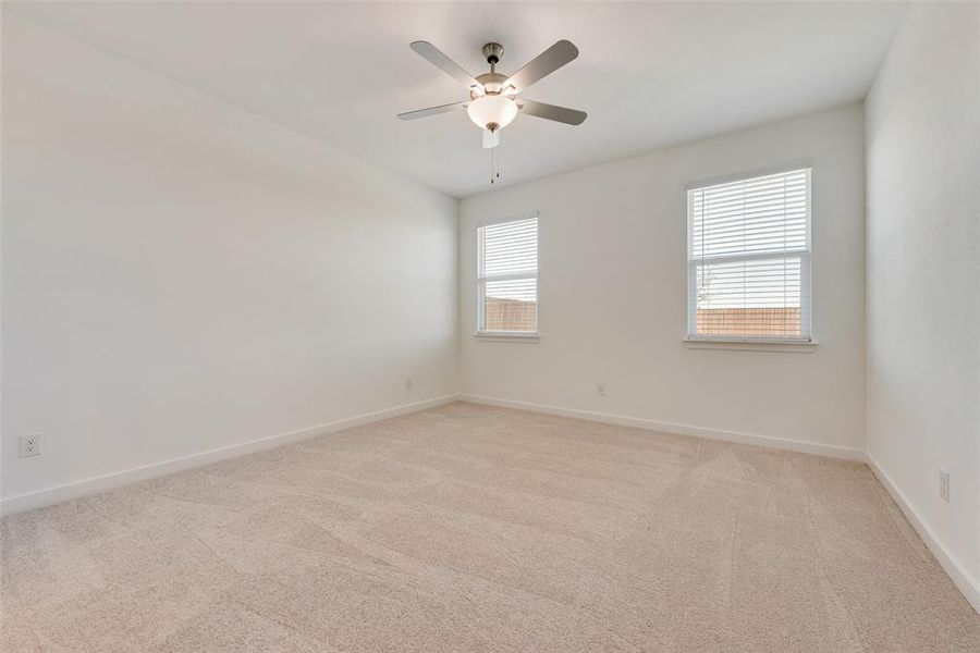 Empty room featuring light carpet and ceiling fan