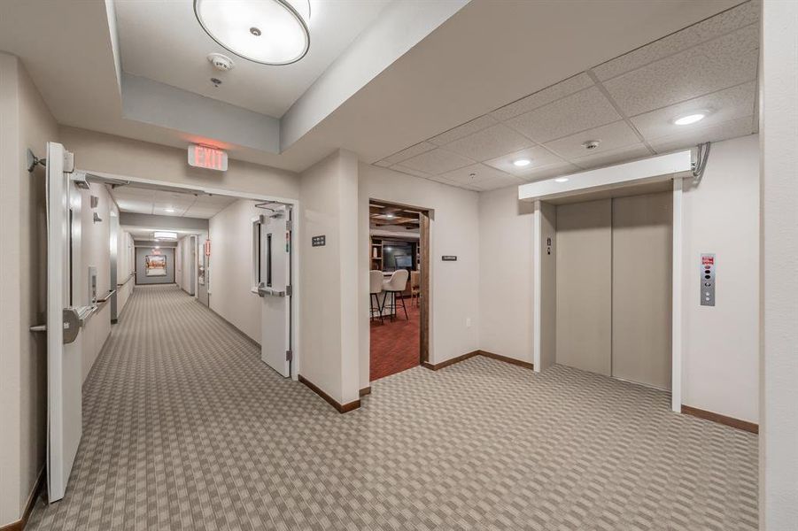 Elevator access between floors, leading to shared community space.