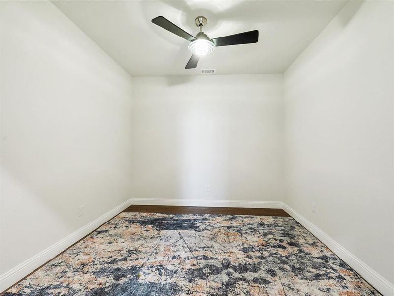 Empty room or office featuring ceiling fan and hardwood / wood-style flooring