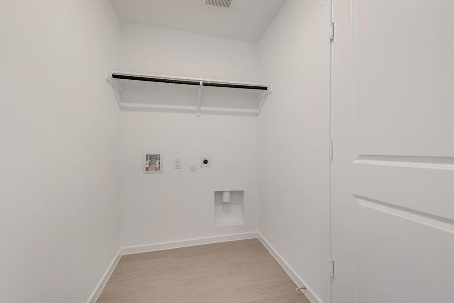 Washroom with electric dryer hookup, light wood finished floors, and hookup for a washing machine