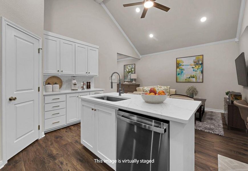 Kitchen featuring dishwasher, white cabinets, an island with sink, light stone counters, and high vaulted ceiling