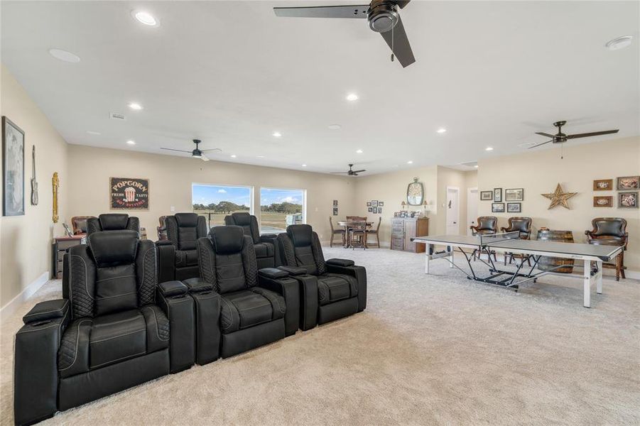 Cinema room with recessed lighting and light colored carpet