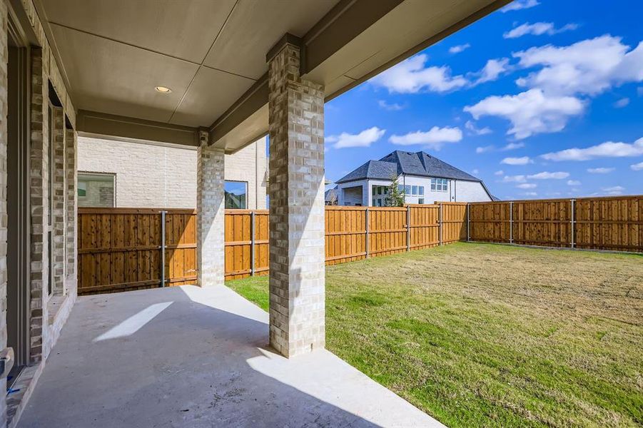 Fenced backyard with a patio area Fenced backyard with a patio area
