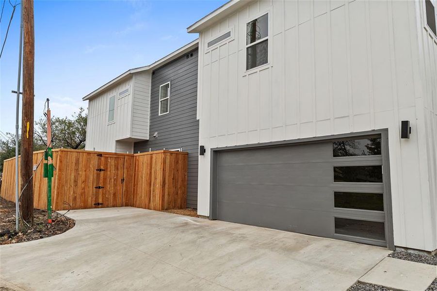 View of property exterior with a gate, a garage, board and batten siding, and concrete driveway View of property exterior with a gate, a garage, board and batten siding, and concrete driveway