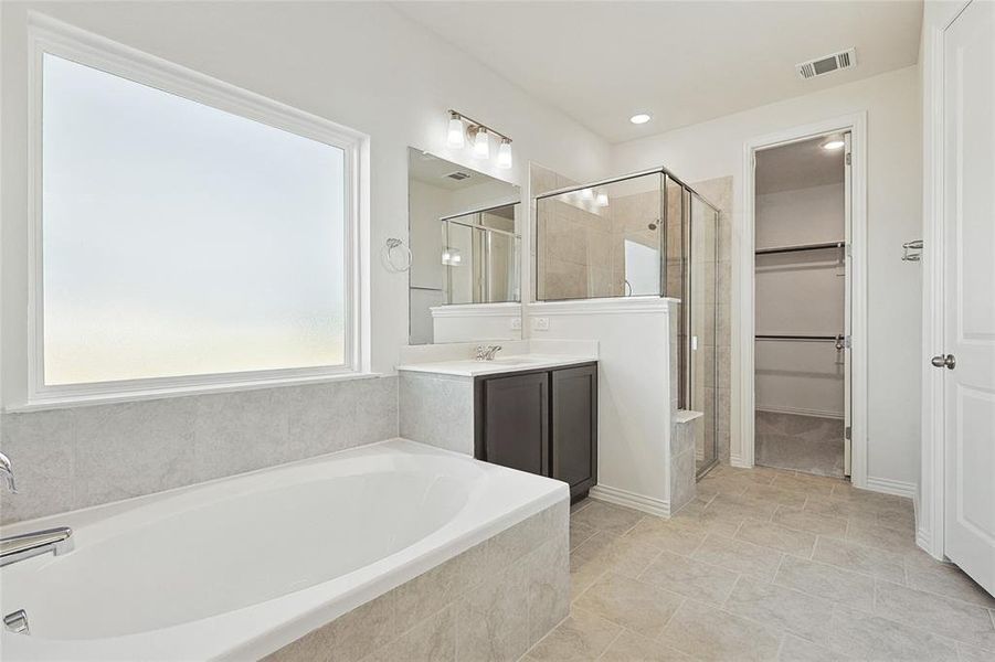 Bathroom featuring tile floors, shower with separate bathtub, and oversized vanity