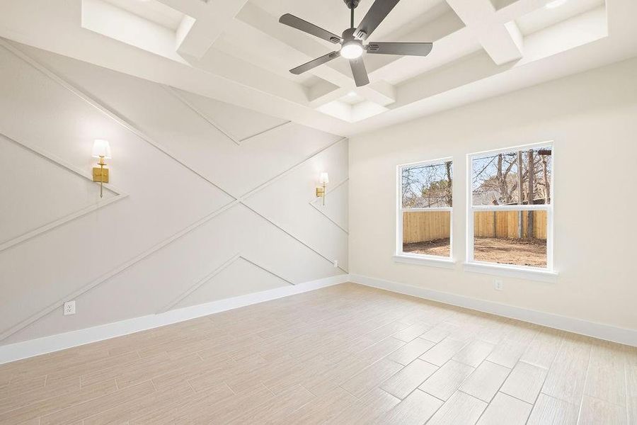 Unfurnished room with ceiling fan, light wood-style flooring, coffered ceiling, baseboards, and beamed ceiling