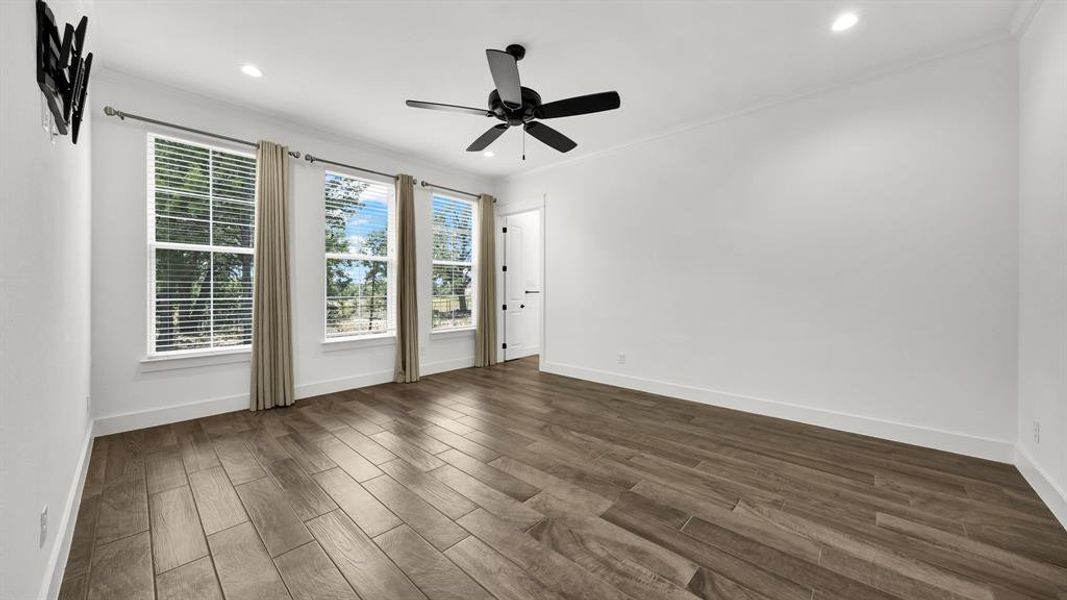 Spare room featuring hardwood / wood-style flooring, ornamental molding, and ceiling fan