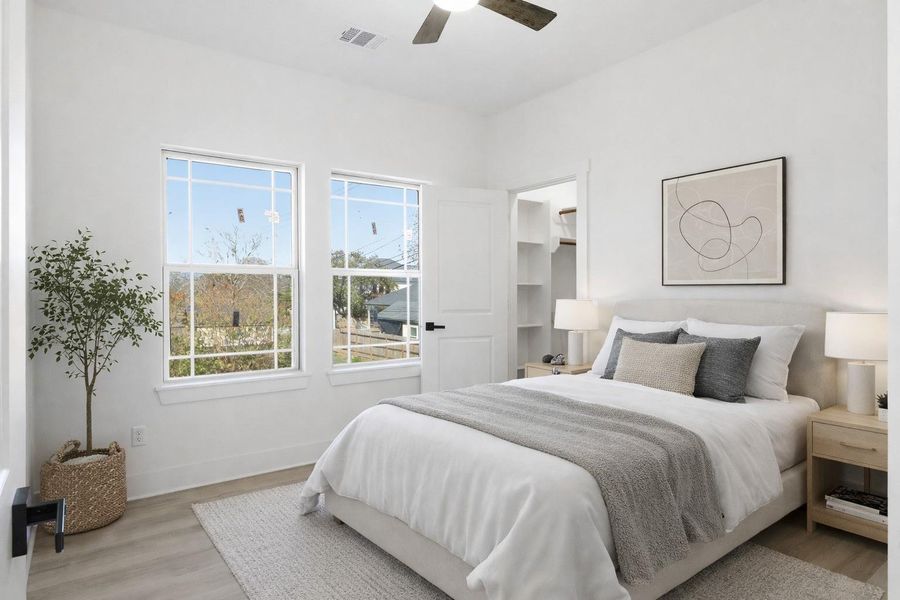 Bedroom 2 upstairs features a ceiling fan, 2 windows & a walk in closet. (staged)