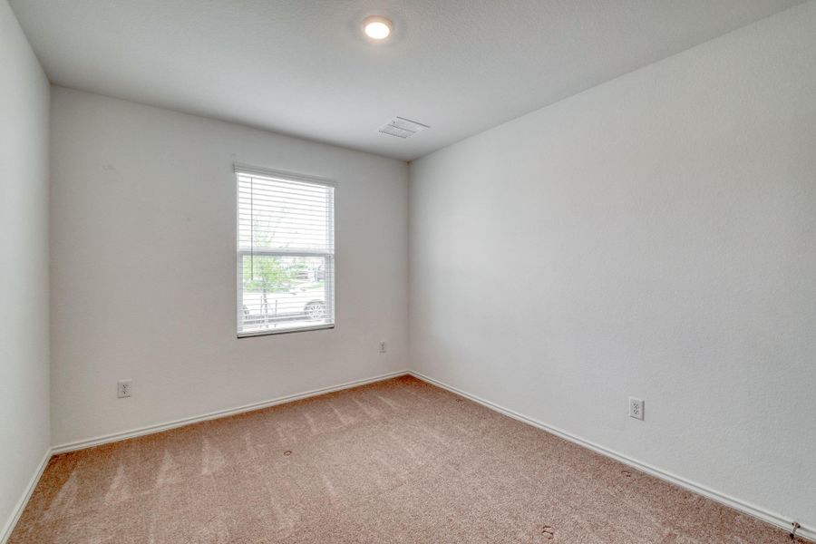 Bright room with neutral wall paint, carpet flooring, a single window with blinds, and recessed lighting