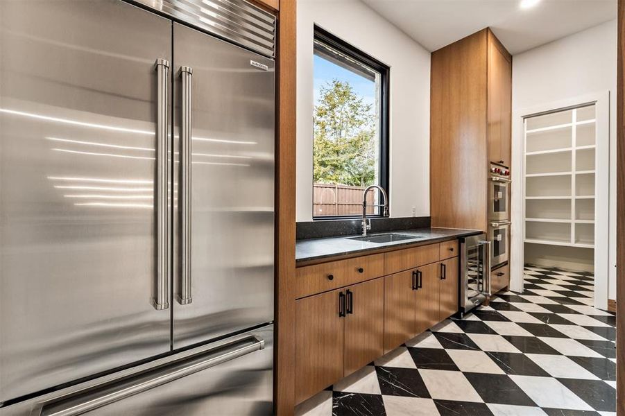 The butler’s pantry feels like a private prep kitchen, offering additional counter space, storage, and room to keep entertaining essentials organized and out of sight