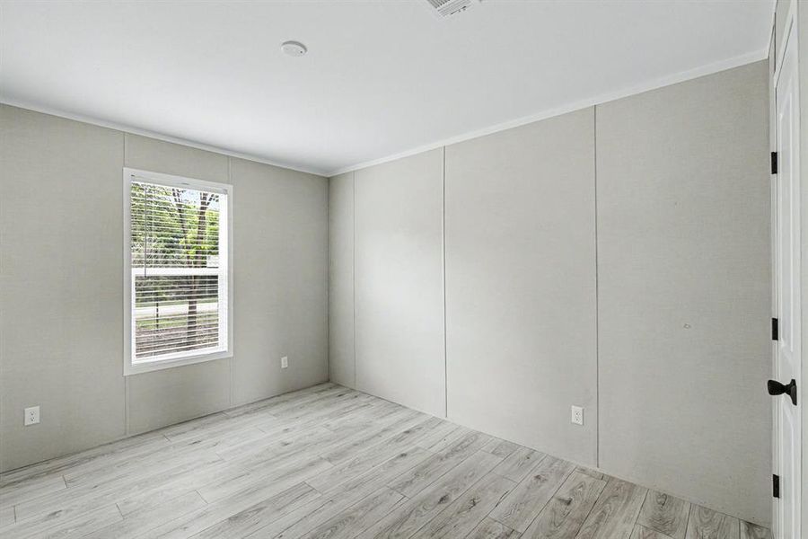Bright interior featuring wood-look flooring, a cloet, and a single window with blinds