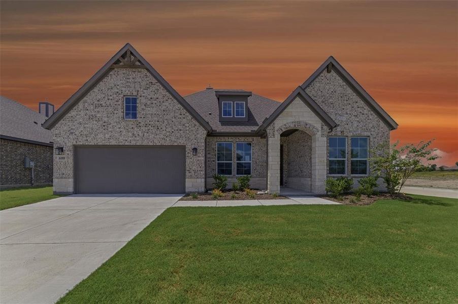 Brick and stone facade featuring a two-car garage, covered entry, dormer windows, and a concrete driveway Brick and stone facade featuring a two-car garage, covered entry, dormer windows, and a concrete driveway