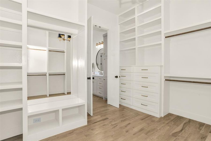 Walk in closet with light wood-style flooring