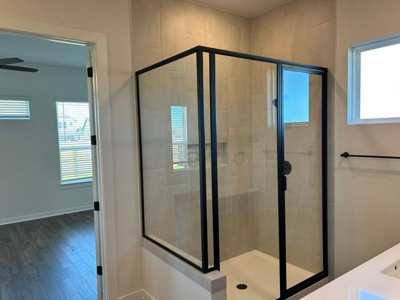 Bathroom featuring a stall shower, vanity, and wood finished floors Bathroom featuring a stall shower, vanity, and wood finished floors