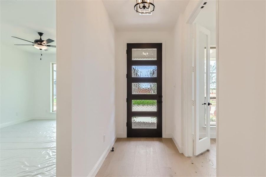 Foyer entrance with wood-type flooring and ceiling fan