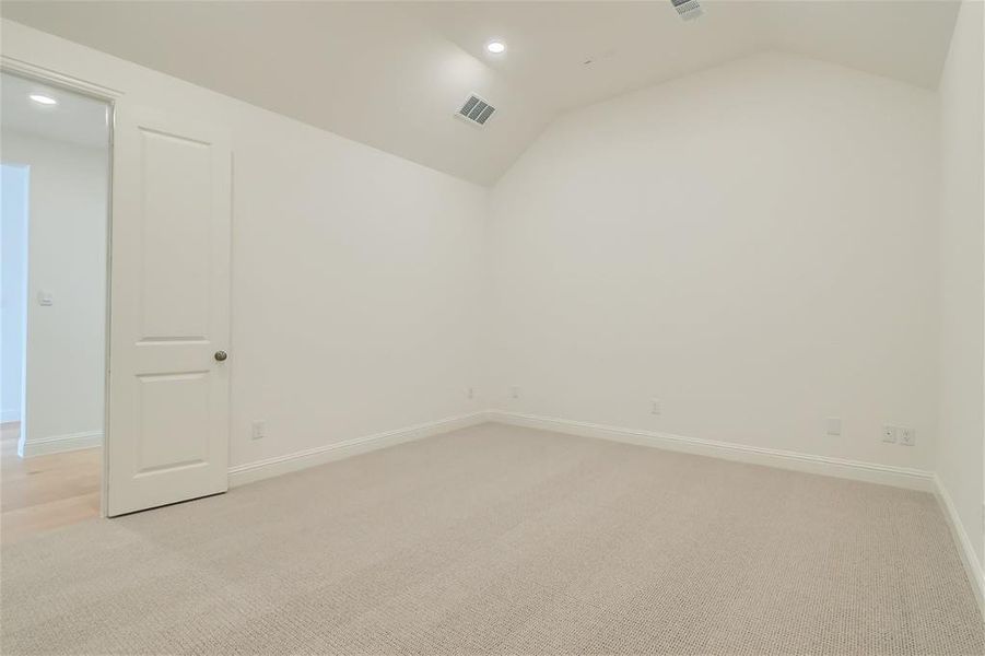 Carpeted empty room with lofted ceiling