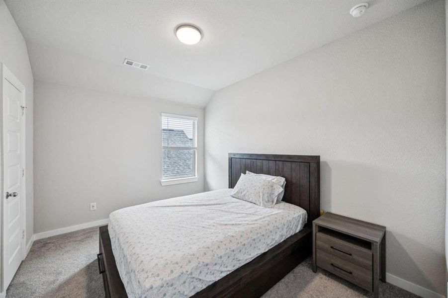 Bedroom with carpet flooring and vaulted ceiling