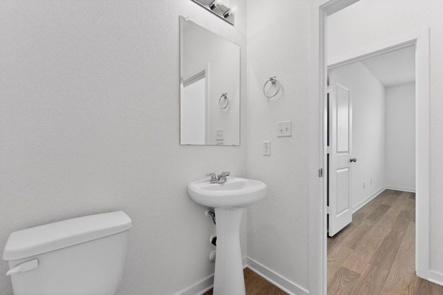 Half bathroom with toilet and light wood-style flooring