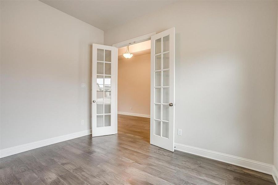 Spare room featuring french doors and hardwood / wood-style floors