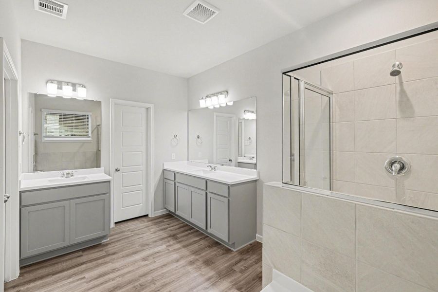 Bright primary bath featuring double sinks, ample counter space, and neutral finishes. Bright primary bath featuring double sinks, ample counter space, and neutral finishes.