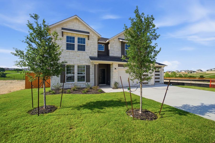 Front exterior of a new home in Lariat, Liberty Hill, TX, highlighting curb appeal (Image 22). Front exterior of a new home in Lariat, Liberty Hill, TX, highlighting curb appeal (Image 22).
