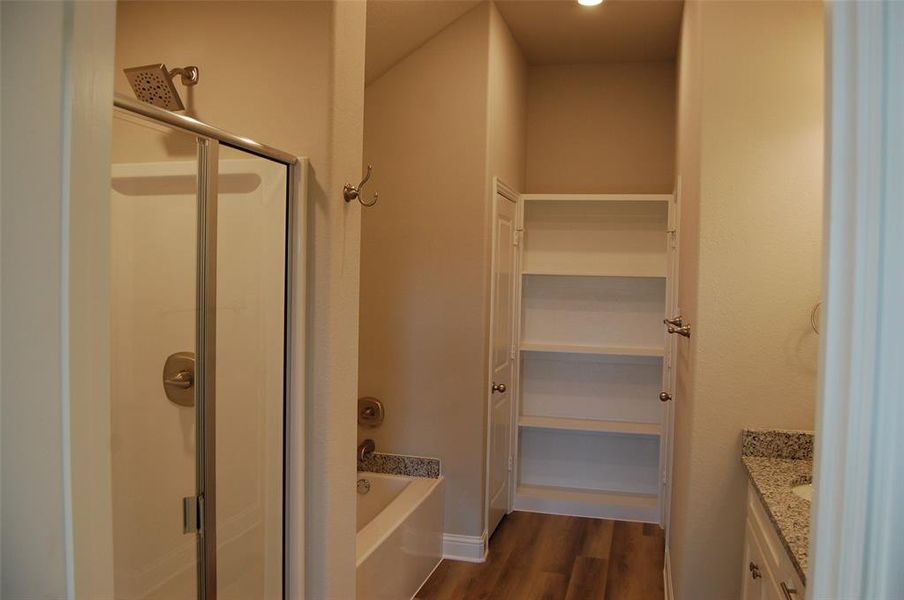 Bathroom with vanity, hardwood / wood-style flooring, and shower with separate bathtub