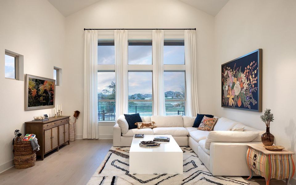 A bright living space features towering windows and durable hardwood flooring. A bright living space features towering windows and durable hardwood flooring.