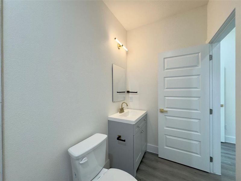 Bathroom with vanity, hardwood / wood-style floors, and toilet